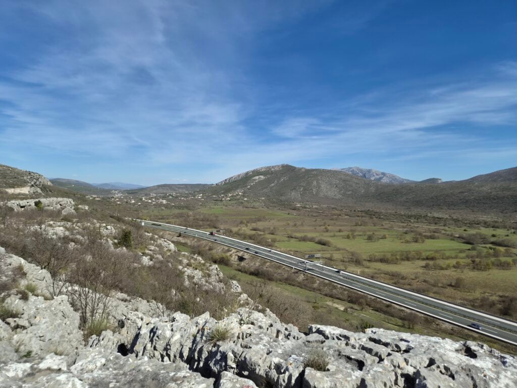 Panoramski pogled na autocestu koja se zavija kroz brdoviti, sušni krajolik, test Samsung Galaxy S26 pejzaža.